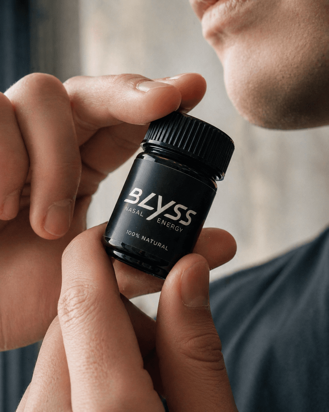 Hand holding BLYSS inhaler close to face in daylight