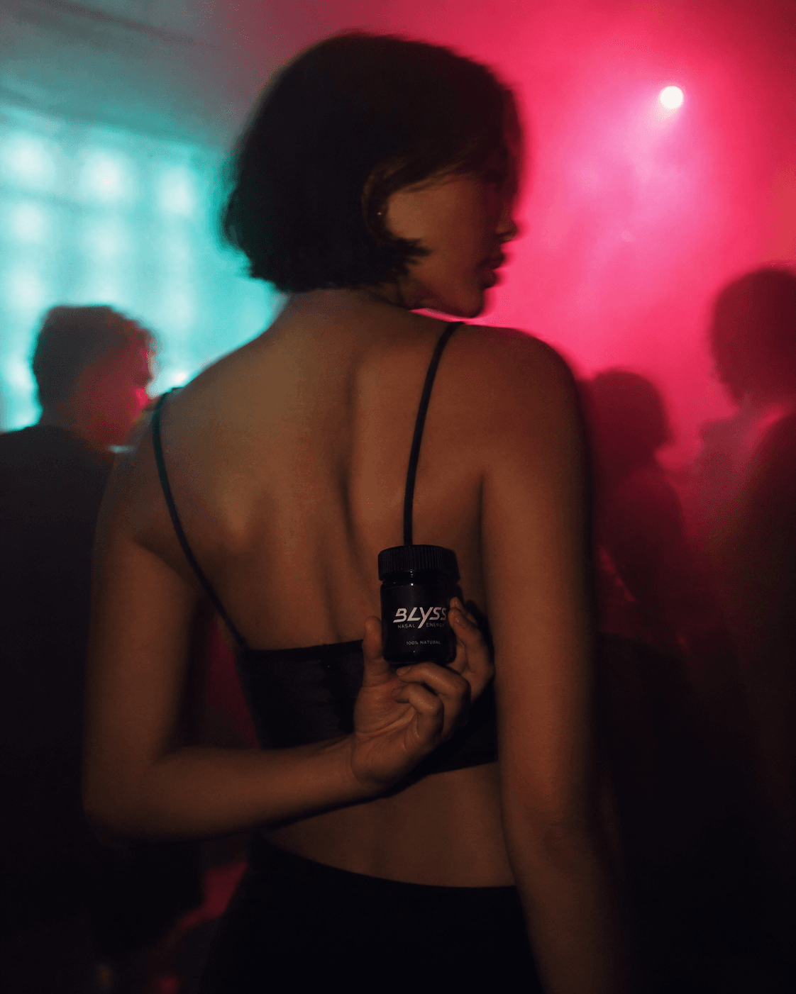 Woman holding BLYSS on a dancefloor at night