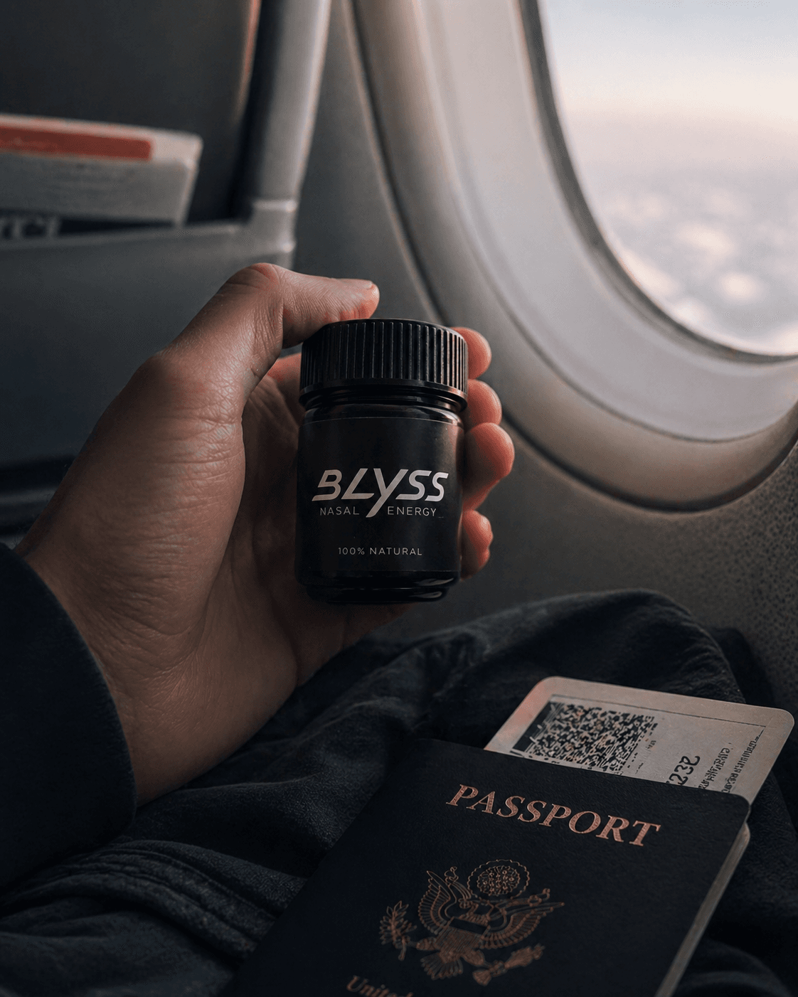 Hand holding BLYSS by an airplane window with passport